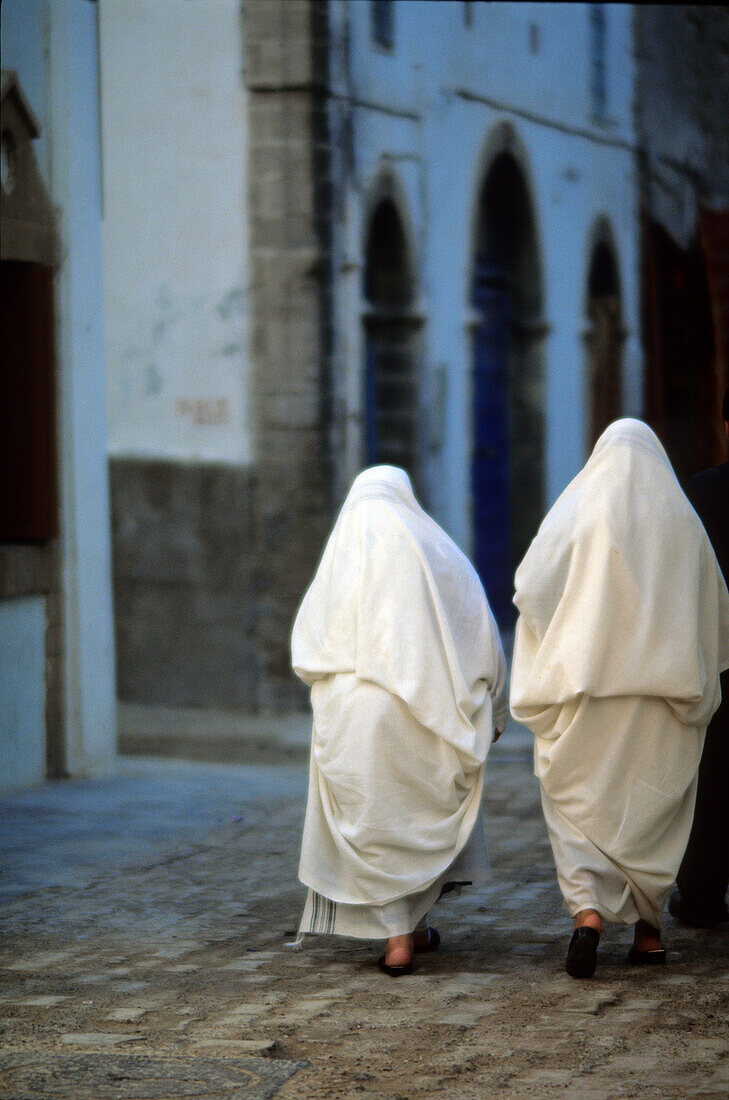 Moroccan Women Wearing White Haiks, Big Veils That Cover The Head And Body, On A Street In Taroudant, Morocco, Africa