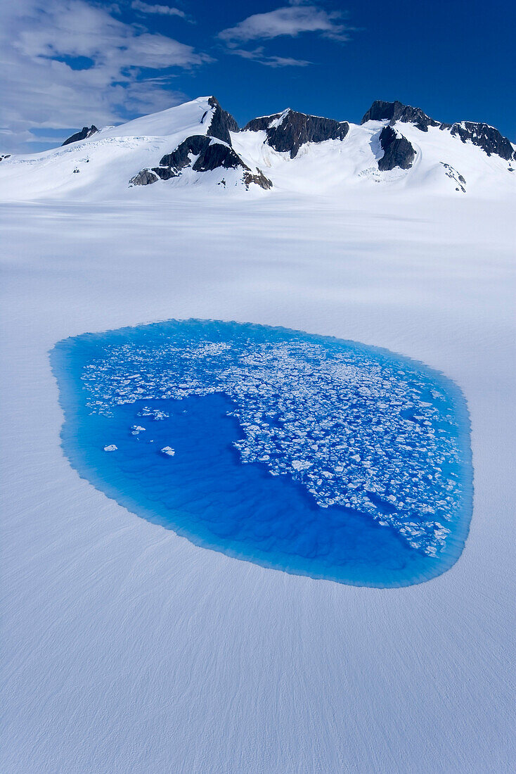 Breaking Surface Ice Reveals The Brilliant Blue Waters Of A Melt Pond On The Juneau Ice Field. Summer In Southeast Alaska.