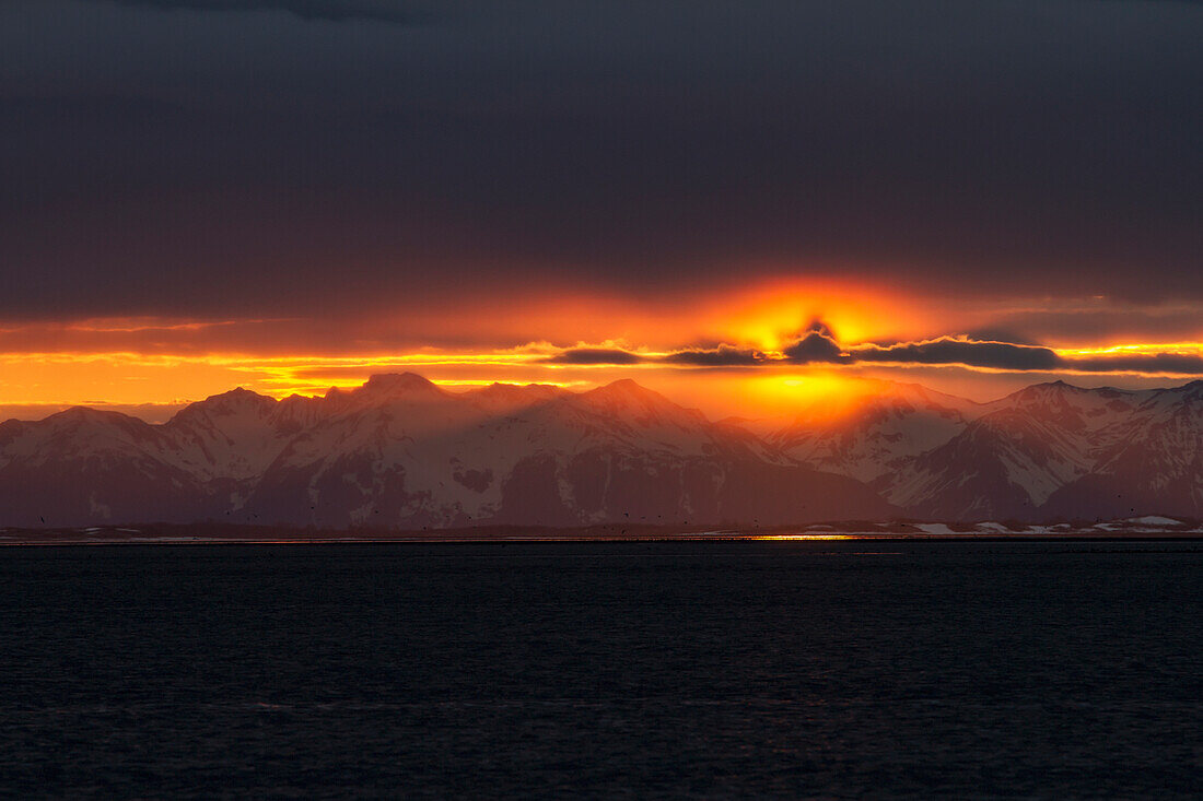 'A Colourful Sunset Below A Cloud Bank Over The Chugach Mountains Turns Into A Surreal Golden Glow During Low Tide On The Copper River Flats Salmon Fishing Grounds; Cordova Alaska United States Of America'