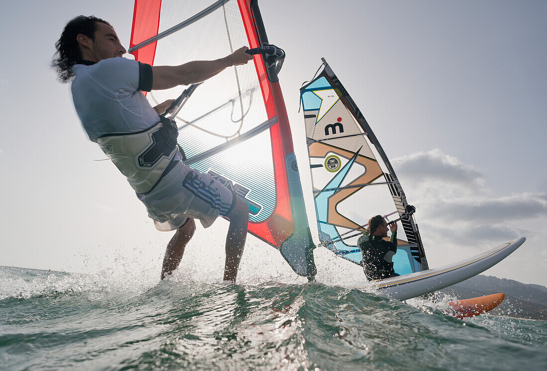 'Two windsurfers side by side in the water; tarifa cadiz andalusia spain'