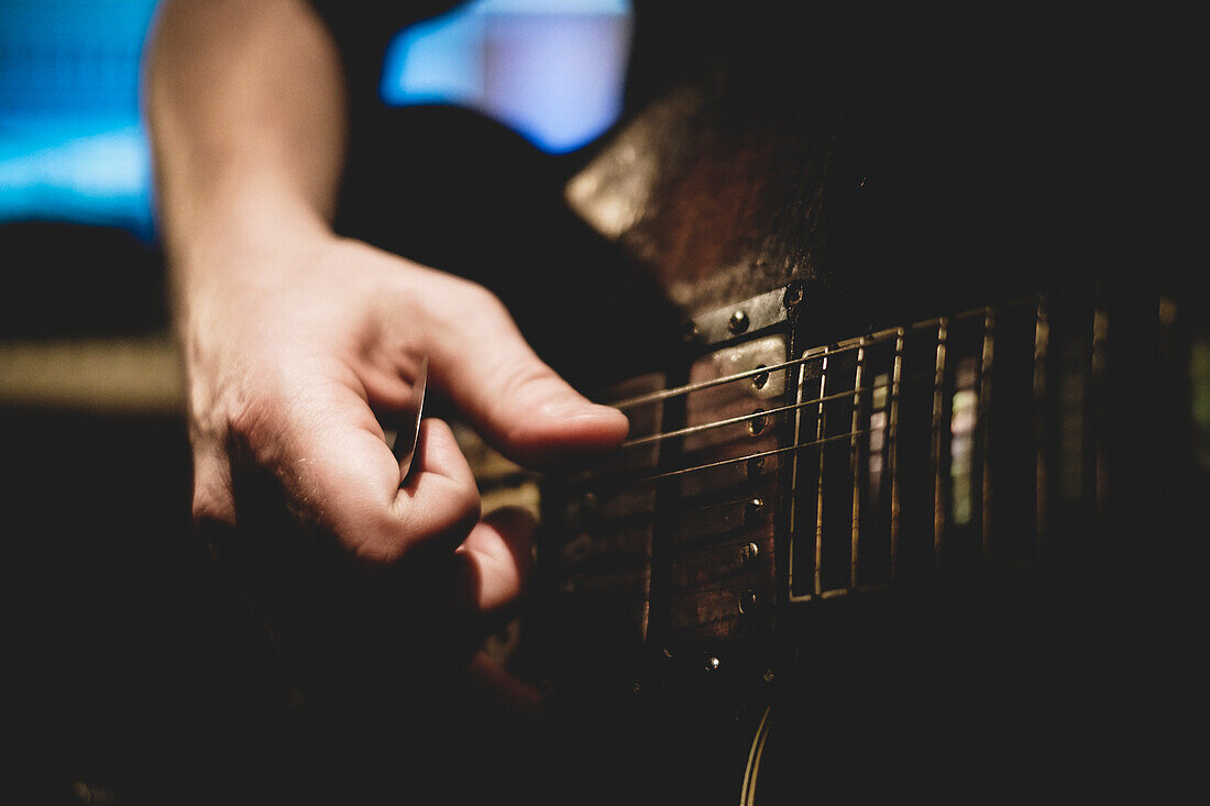 'Close-Up Of Guitar Player's Hand Holding Pick And Strumming Strings;Montreal Quebec Canada'