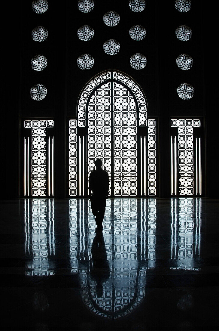 'Morocco, Silhouette Of Person Standing In Front Of Ornate Wall In Hassan Ii Mosque With Reflection On Shiny Floor; Casablanca'