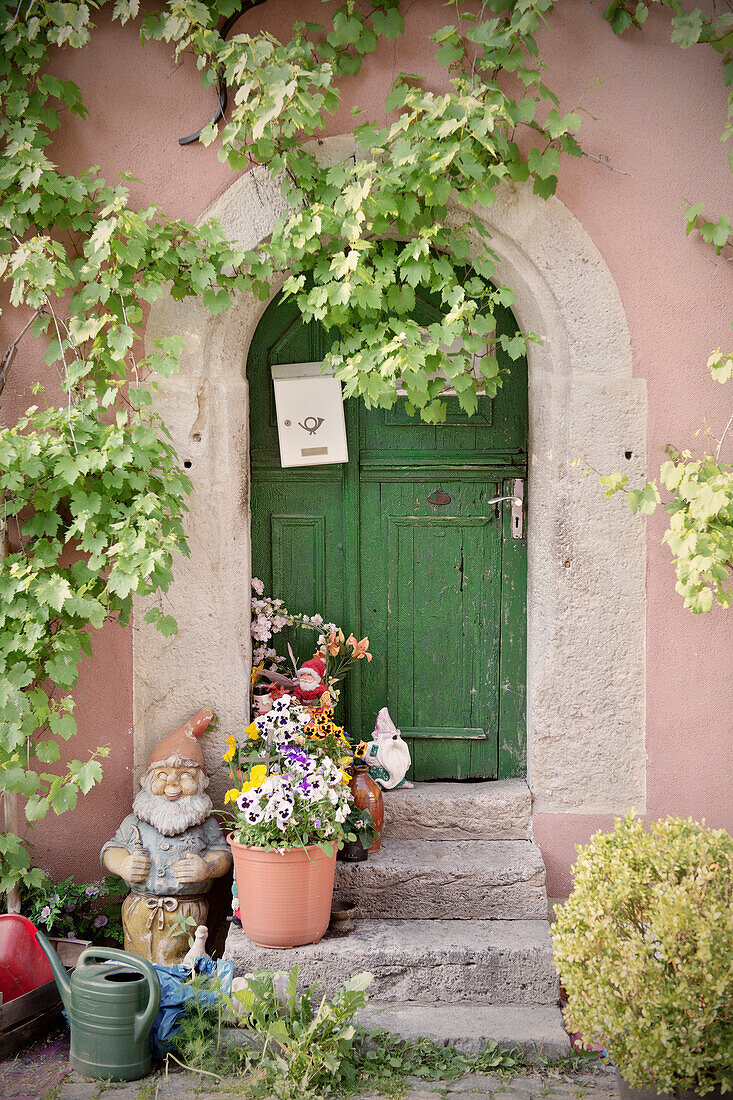 Decorated front door with flowers and garden gnome, Rothenburg ob der Tauber, Romantic Road, Franconia, Bavaria, Germany