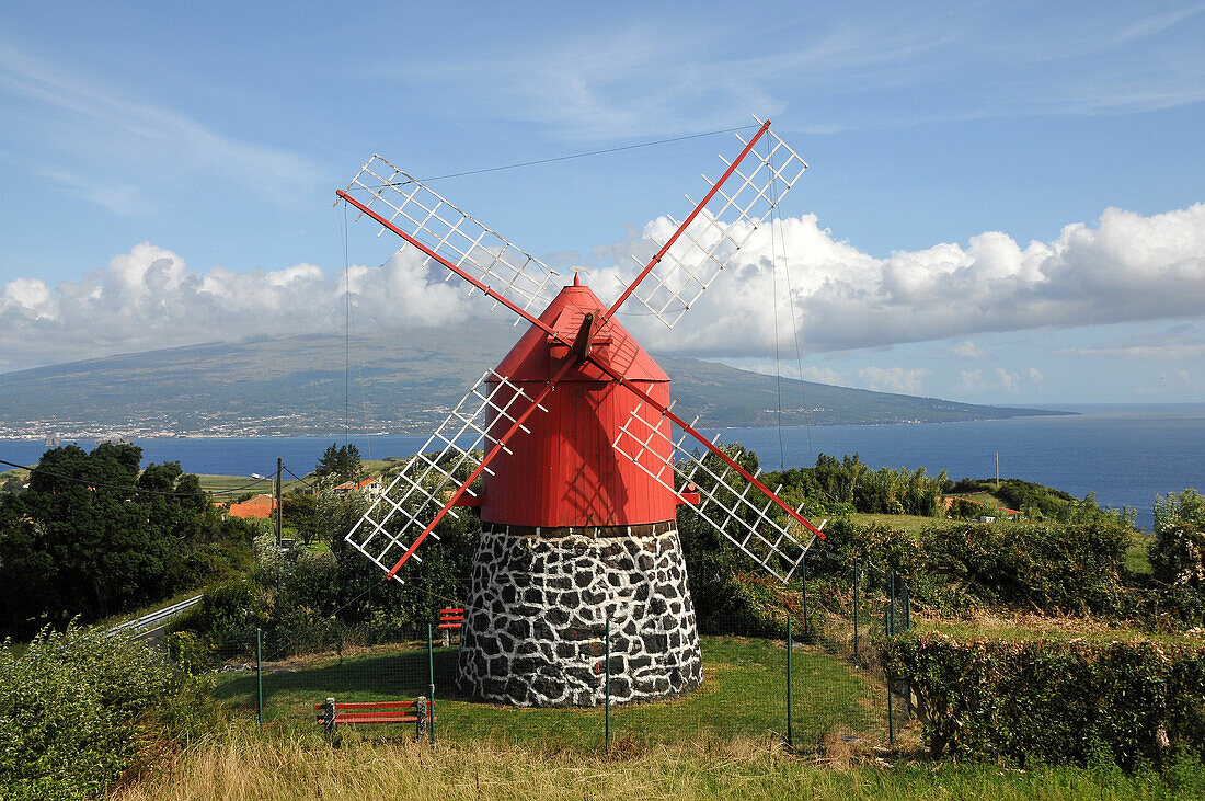 Windmill over Praia do Almoxarife with Pico Vulcano in the background, Island of Faial, Azores, Portugal