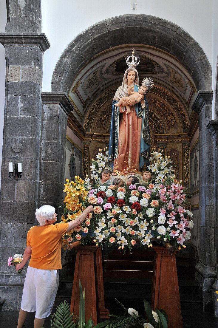 Madonna figure being decorated with flowers, Provocao, Island of Sao Miguel, Azores, Portugal
