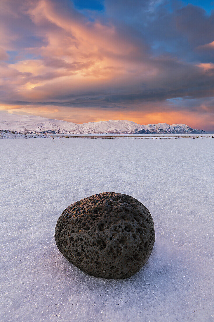 Piece of lava rock laying in the snow around the area of Husey, Iceland
