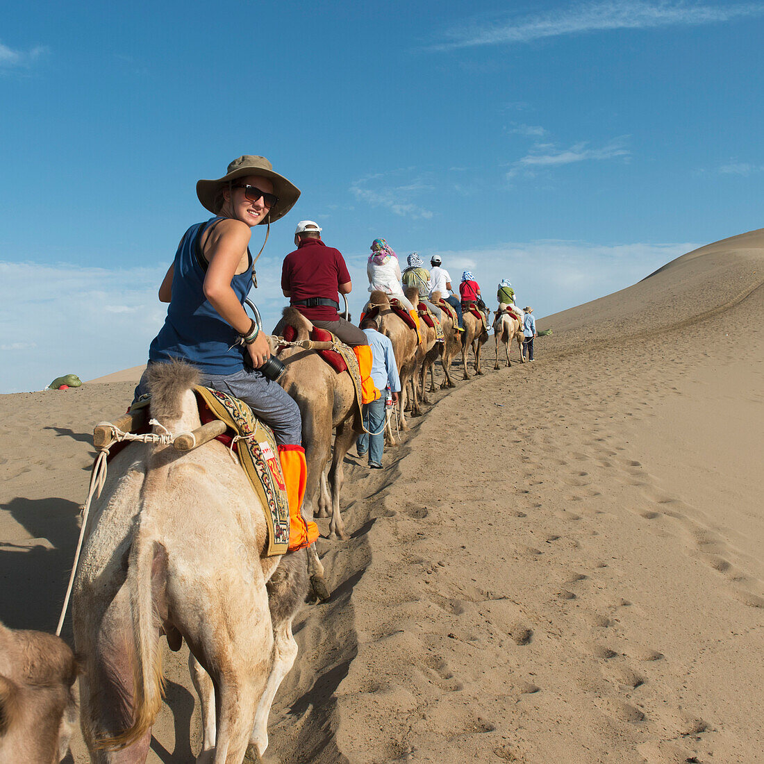 Tourists ride in a row on camels, Jiuquan, Gansu, China