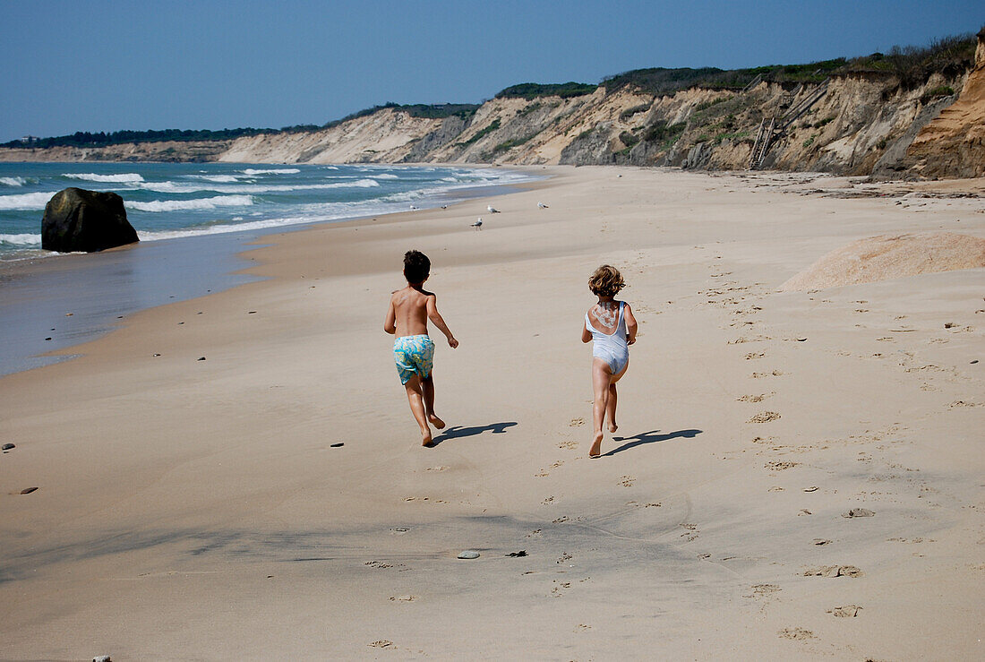 Boy and Girl Running on Sandy Beach