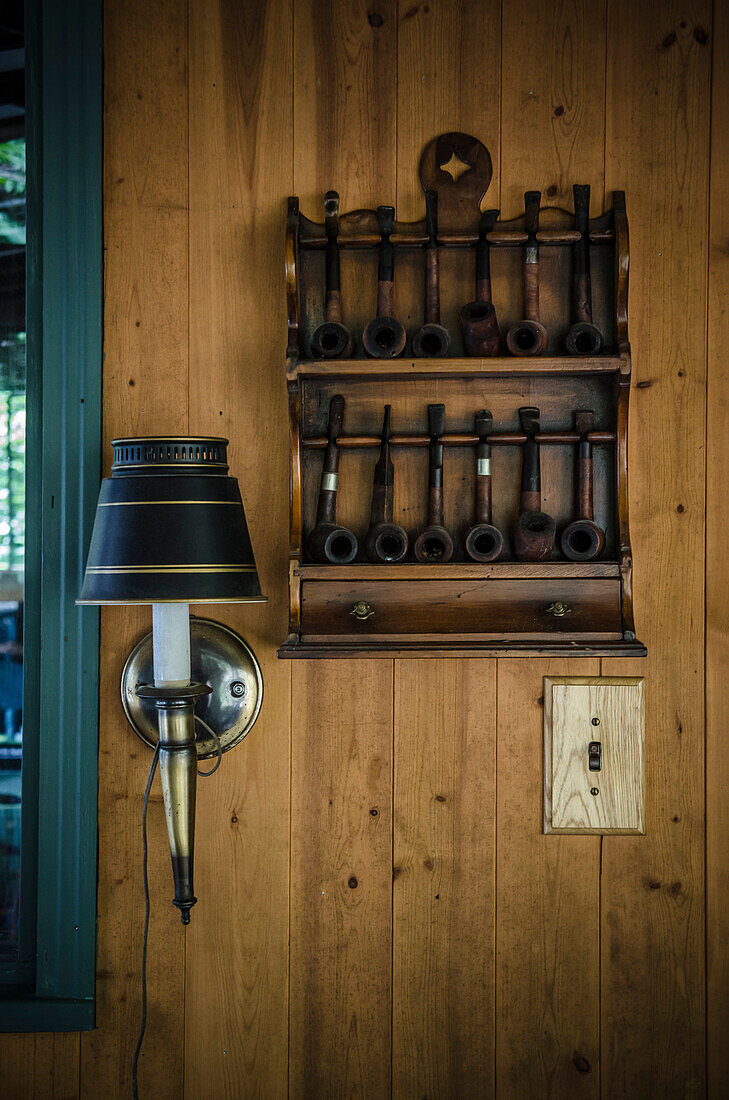 Smoking Pipe Collection and Lamp on Inside Wall of Cottage