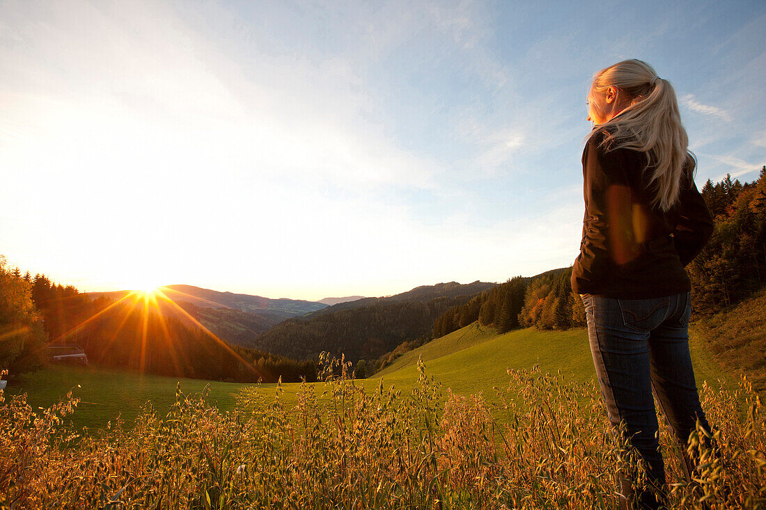 Young woman enjoying sunrise, Styria, Austria