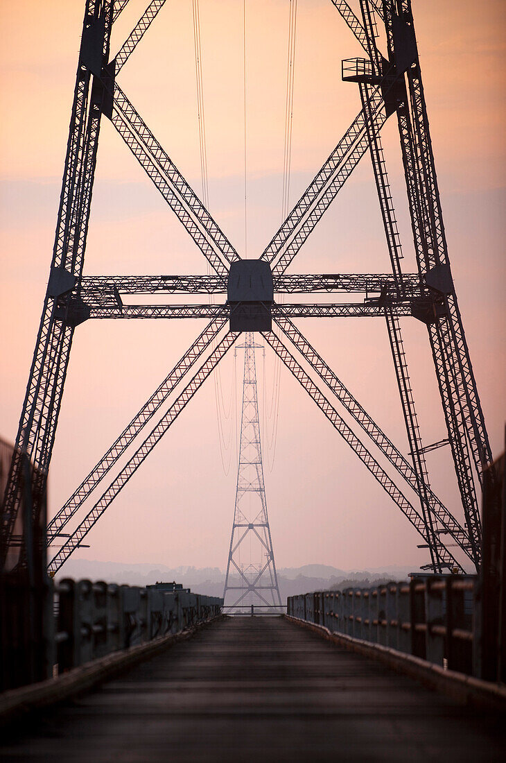 Strommasten an einer Brücke im Sonnenuntergang, Wales, Großbritannien