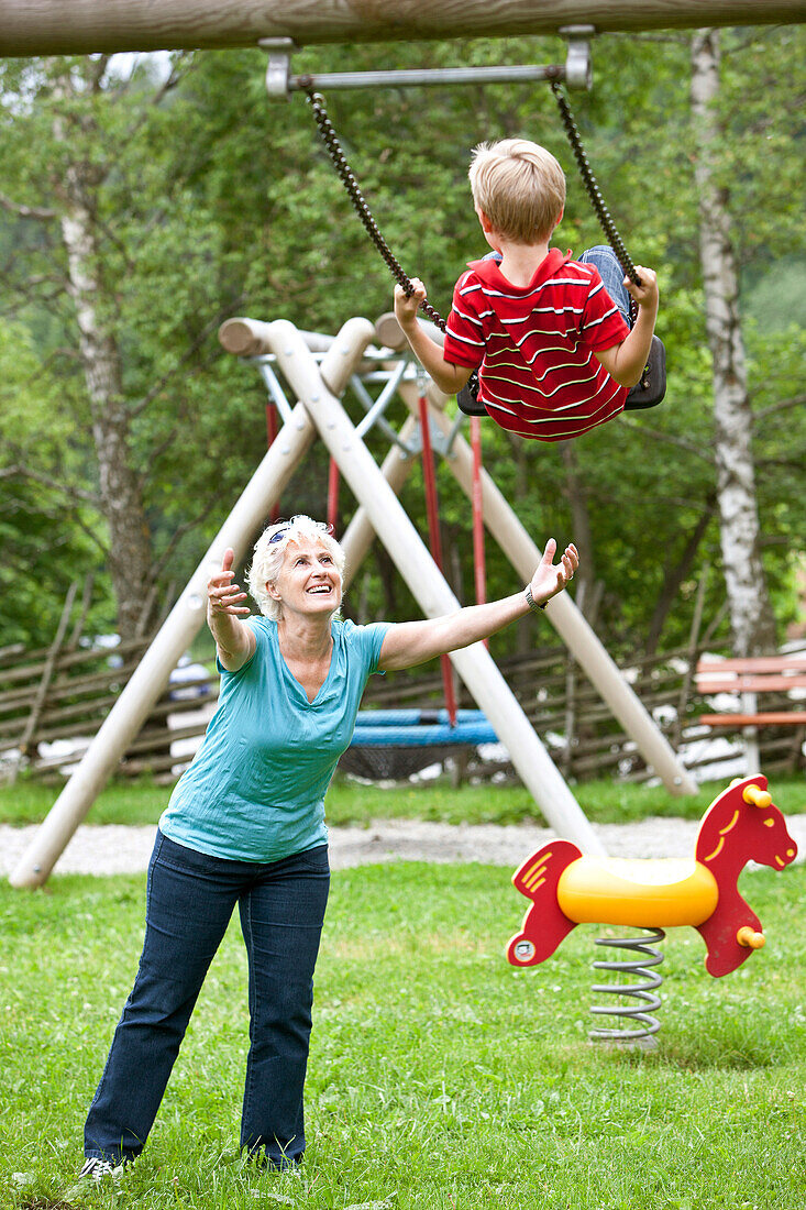 Großmutter und Enkelsohn (7 Jahre) auf einem Spielplatz, Steiermark, Österreich