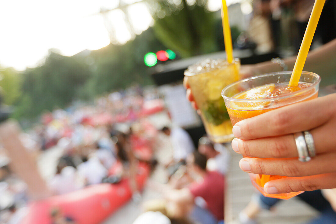 Woman holding drinks, Kulturstrand at Corneliusbruecke, Munich, Bavaria, Germany