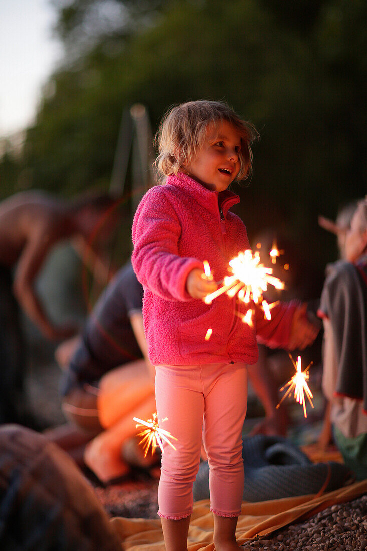 Girl with sparkler at lake Starnberg, Ammerland, Munsing, Upper Bavaria, Germany