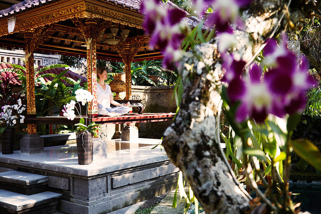 Woman meditating in a pavilion, Ubud, Bali, Indonesia