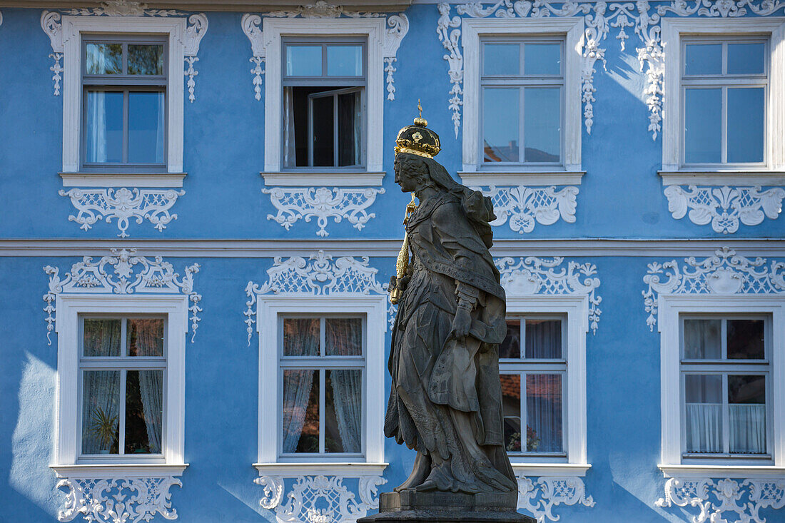 Statue on Untere Bruecke bridge with blue building behind, Bamberg, Franconia, Bavaria, Germany