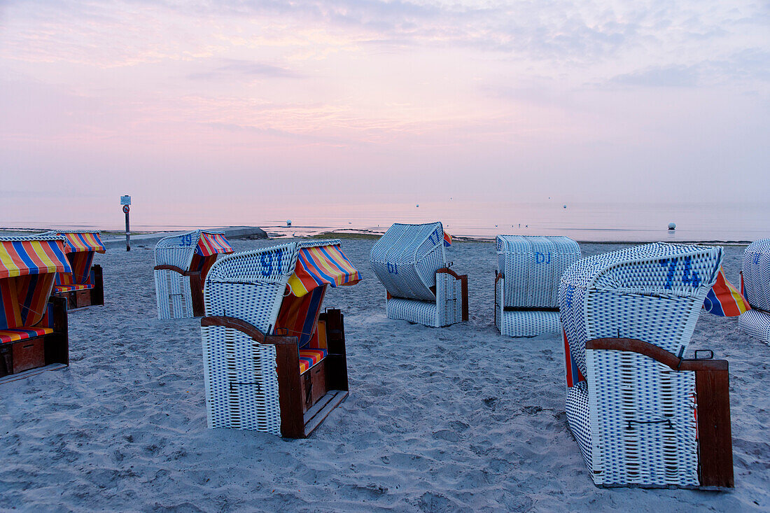 Hooded beach chairs on the beach at sunset, Baltic sea, Groemitz, Schleswig-Holstein, Germany