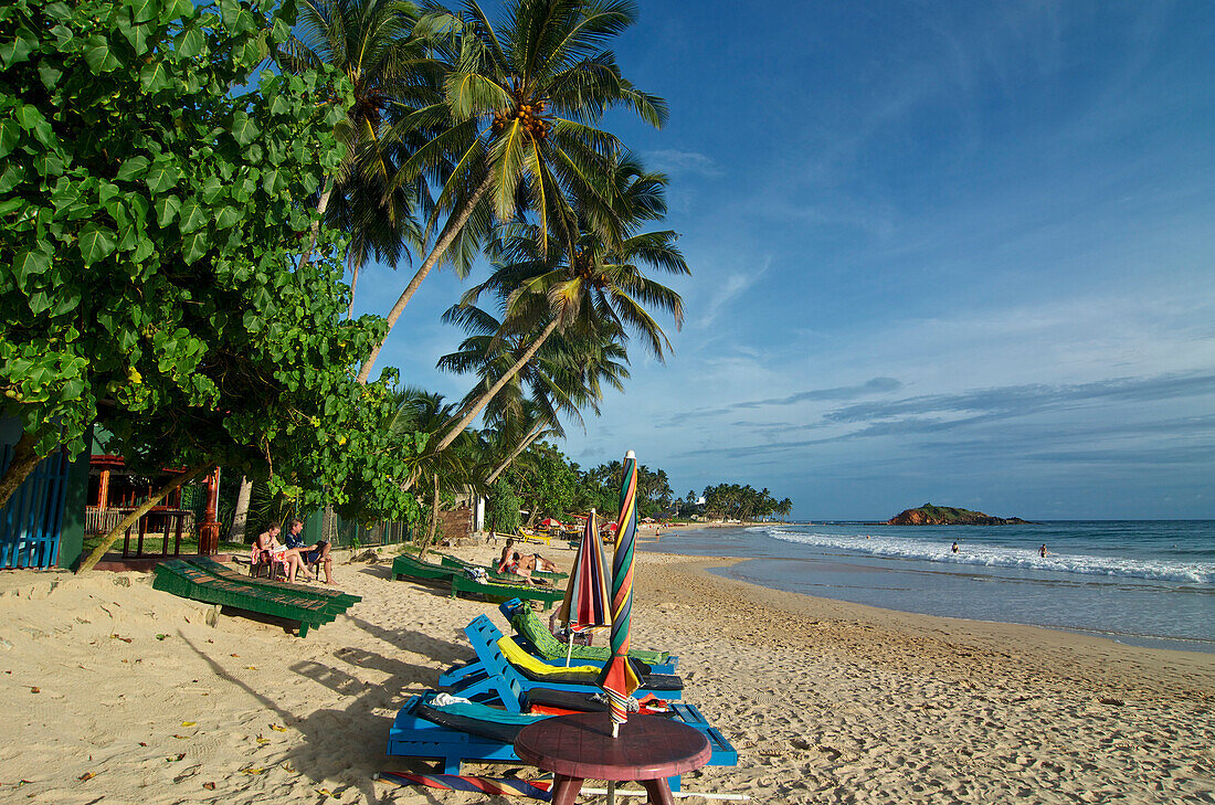 Palmen und Strandliegen am Strand von Mirissa im Süden von Sri Lanka, Südasien