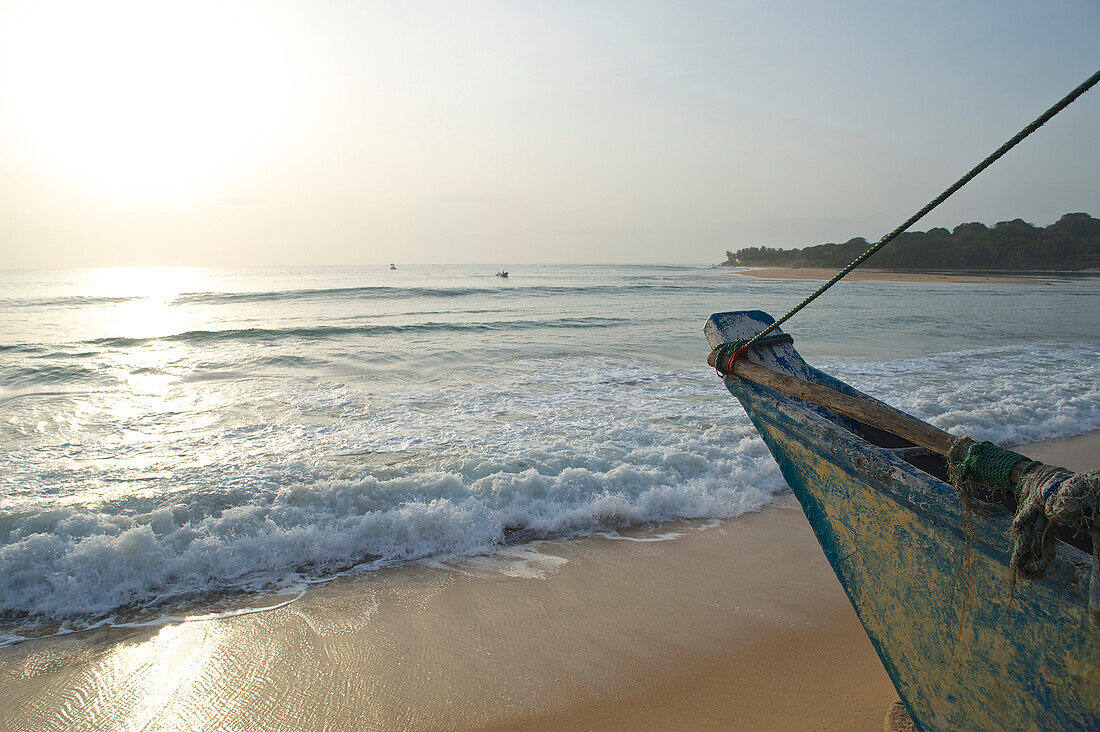 Fischerboot am frühen Morgen am Strand mit Blick auf das Meer, Arugam Bay, Ostküste. Sri Lanka