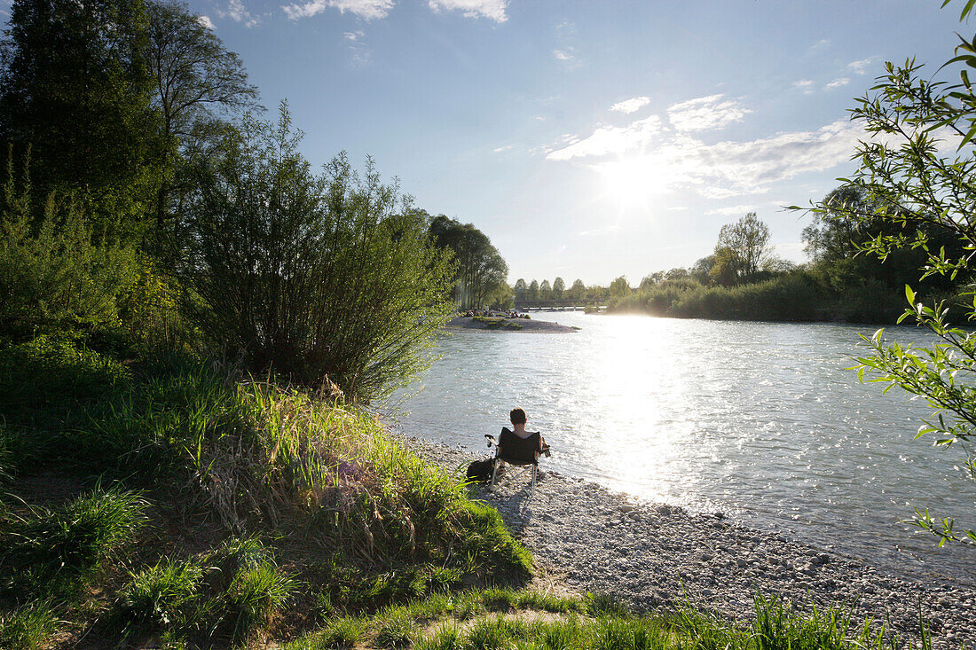 Person sitting at river Isar, Flaucher, Munich, Bavaria, Germany