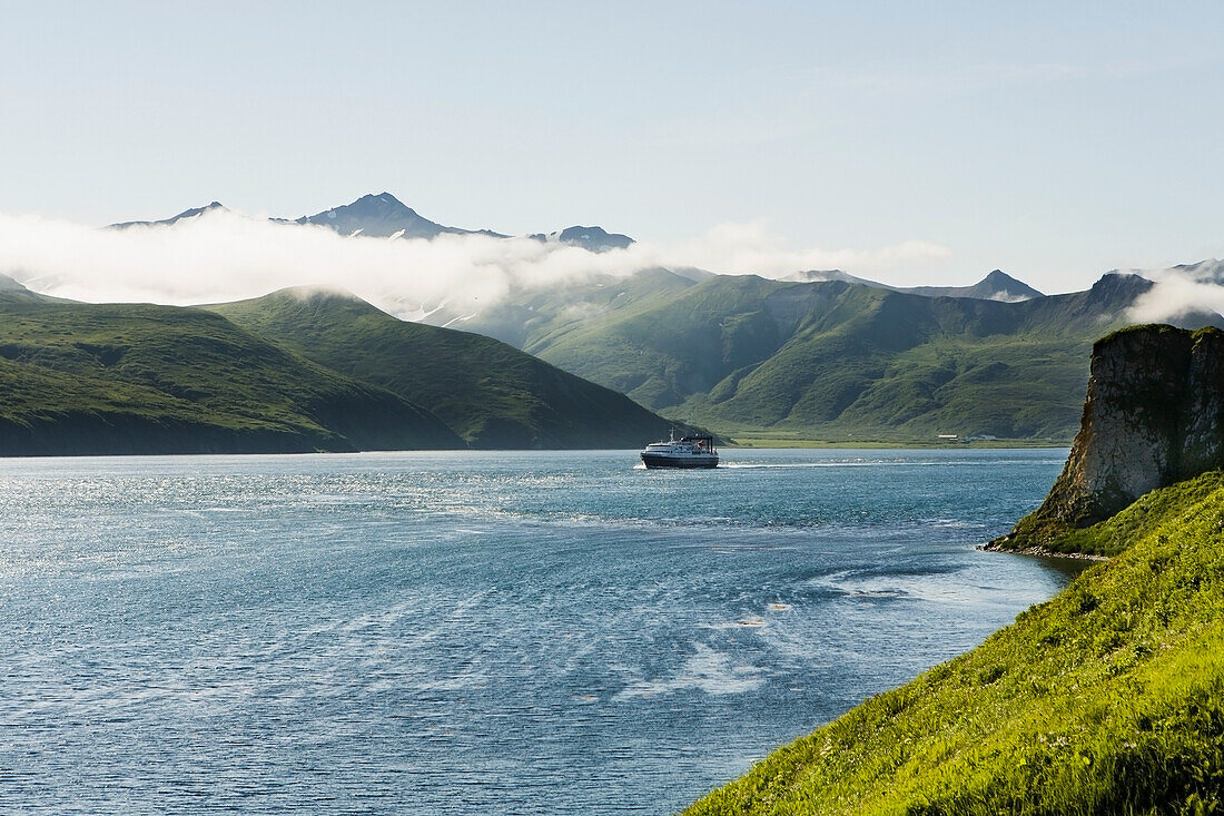 The Alaska Marine Highway ferry M/V Tustumena motoring through False Pass at the edge of the Aleutian Islands, Southwest Alaska, summer.