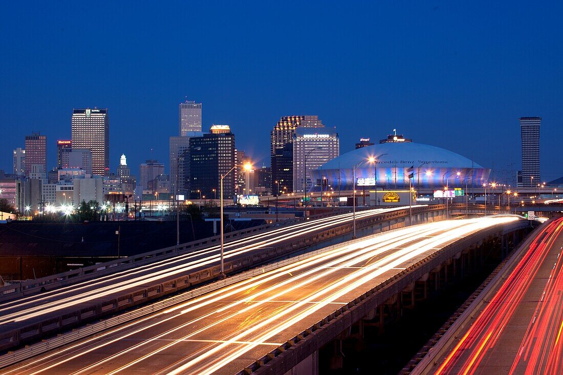 View of the Downtown New Orleans Skyline from I-10 at night with flowing trafic on the highway