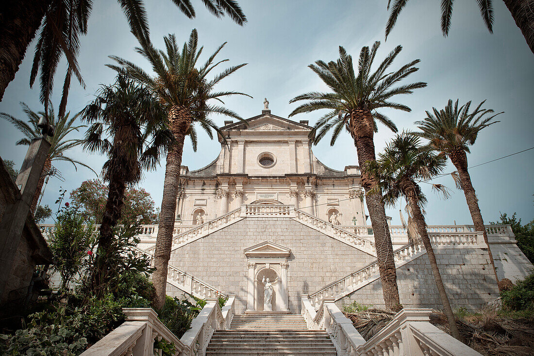 Pompöser Treppenaufgang mit Palmen zur Church of the Birth of our Lady Kirche, Prcanj, Bucht von Kotor, Adria Mittelmeerküste, Montenegro, Balkan Halbinsel, Europa