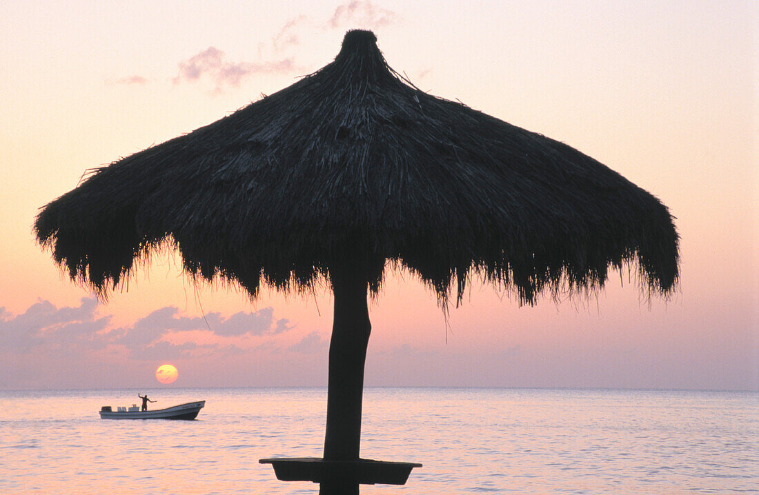 St. Lucia, Anse Chastanet Resort, Caribbean Sea, local fisherman, palm frond umbrella, sunset
