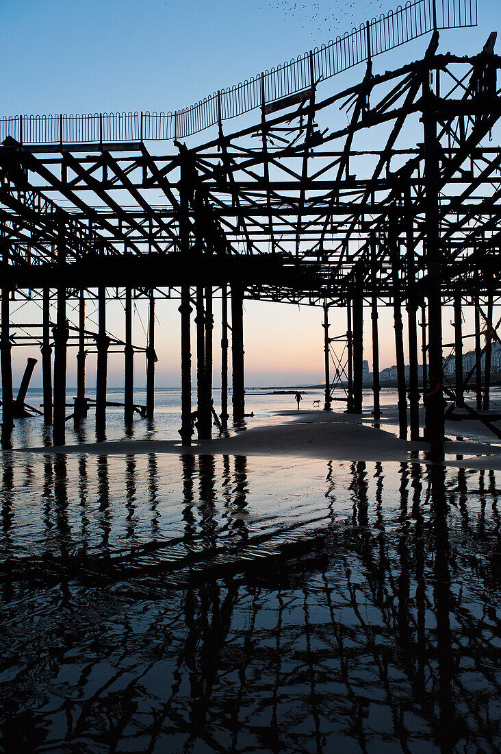 View of old pier at sunset, Hastings, East Sussex, England