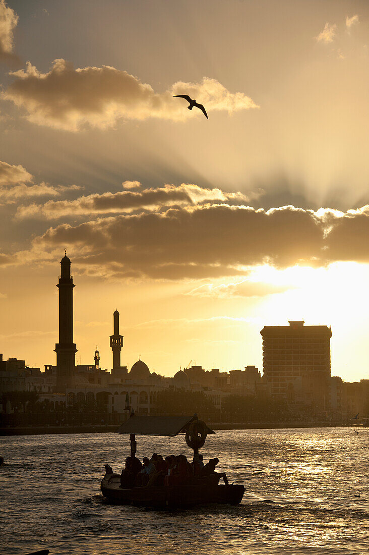 People on water taxi at dusk at the Creek, Dubai, UAE