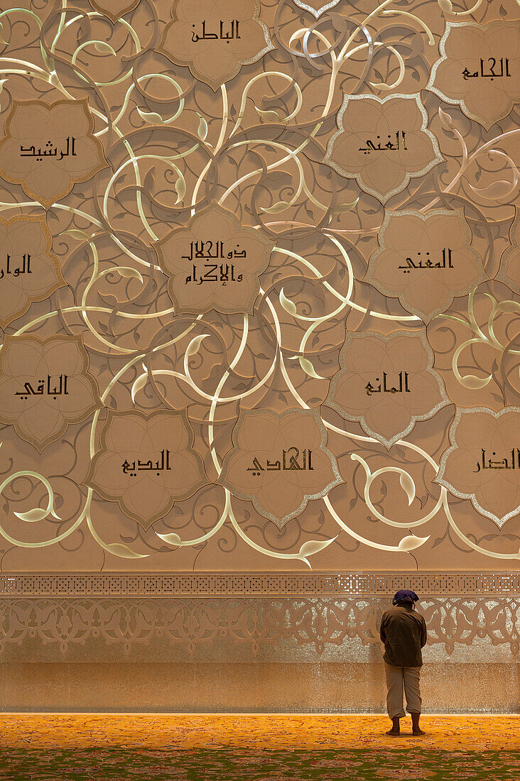 Man praying in front of Qibla wall in Sheikh Zayed Grand Mosque, Abu Dhabi, UAE