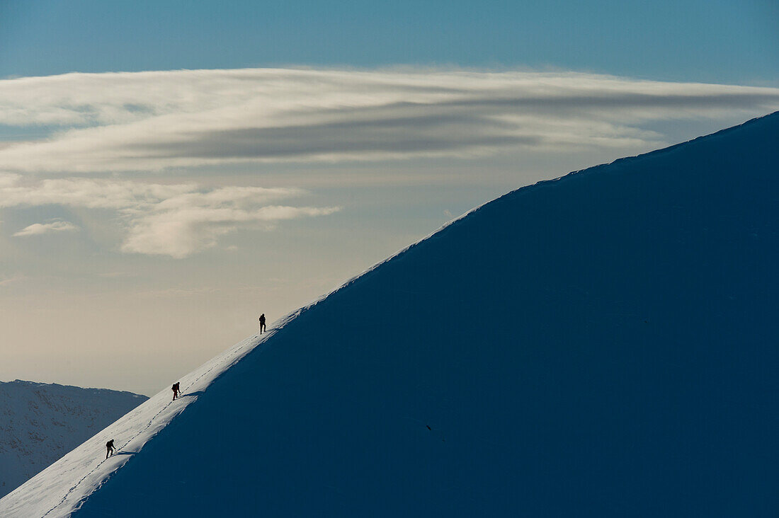 Walkers climbing snowy ridge of Sgorr Dhearg in winter near Glen Coe (Glencoe), Highlands, Scotland, UK