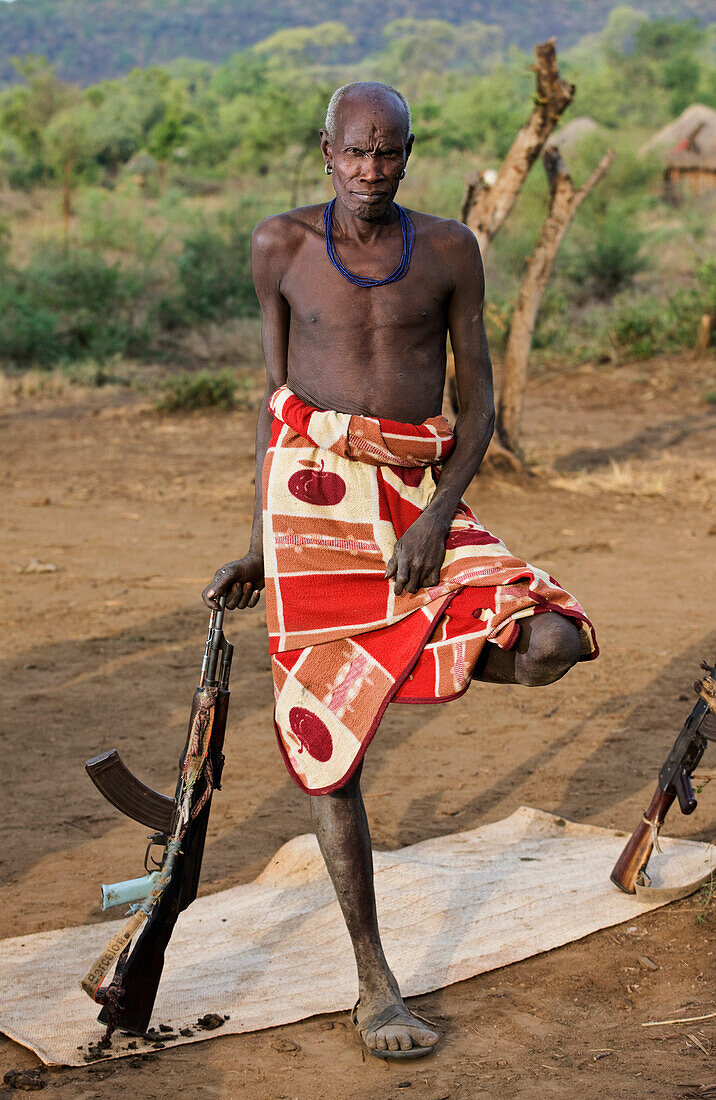 Ethiopia, Southern Nations Nationalities and Peoples' Region, South Omo, Mursiland, Portrait of Mursi tribal man with gun, Maridungka village