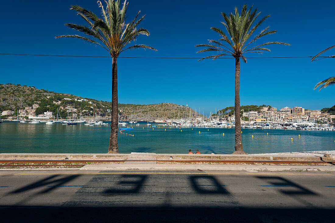 Shadows of letters from Eden Hotel on road in front of beach of Port Soller, Majorca, Spain