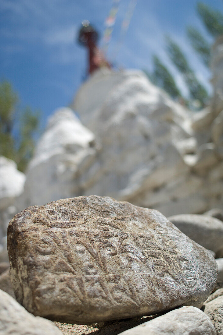 Carved mane stone in front of the Gomang Stupa in Changspa, Leh.  Leh was the capital of the Himalayan kingdom of Ladakh, now the Leh District in the state of Jammu and Kashmir, India.  Leh is at an altitude of 3, 500 meters (11, 483 ft).  © James Sparsha