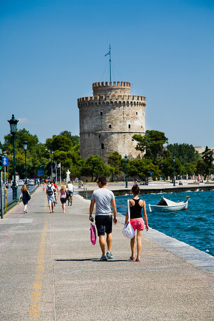Couple walking towards The White Tower, Thessaloniki, Greece