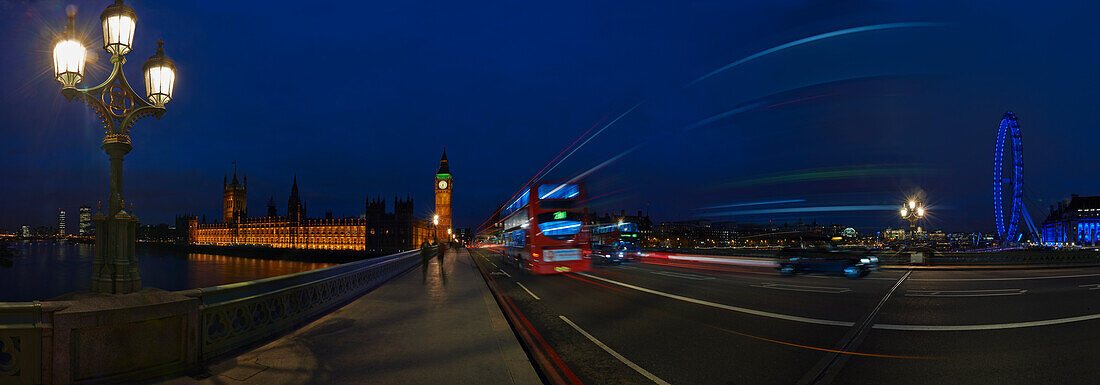 Panoramic view of Westminster Bridge with traffic at night with Houses of Parliament and London Eye in background, London, UK