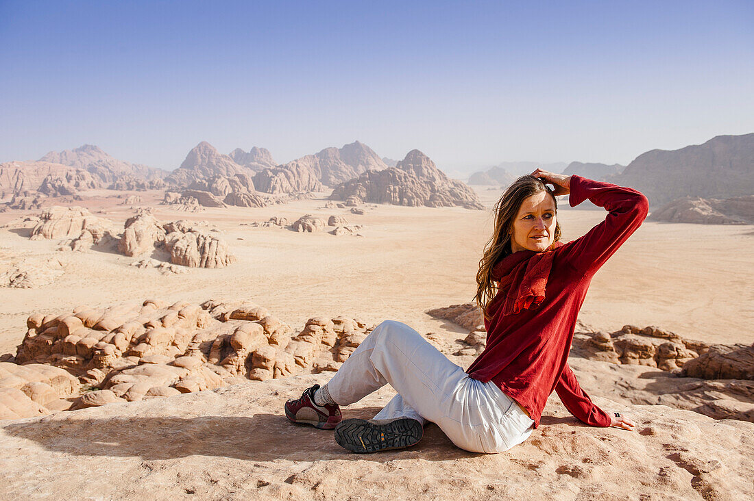 Woman resting on a rock, Wadi Rum, Jordan, Middle East