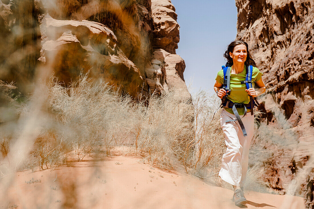 Frau wandert durch eine Felsenschlucht, Wadi Rum, Jordanien, Naher Osten