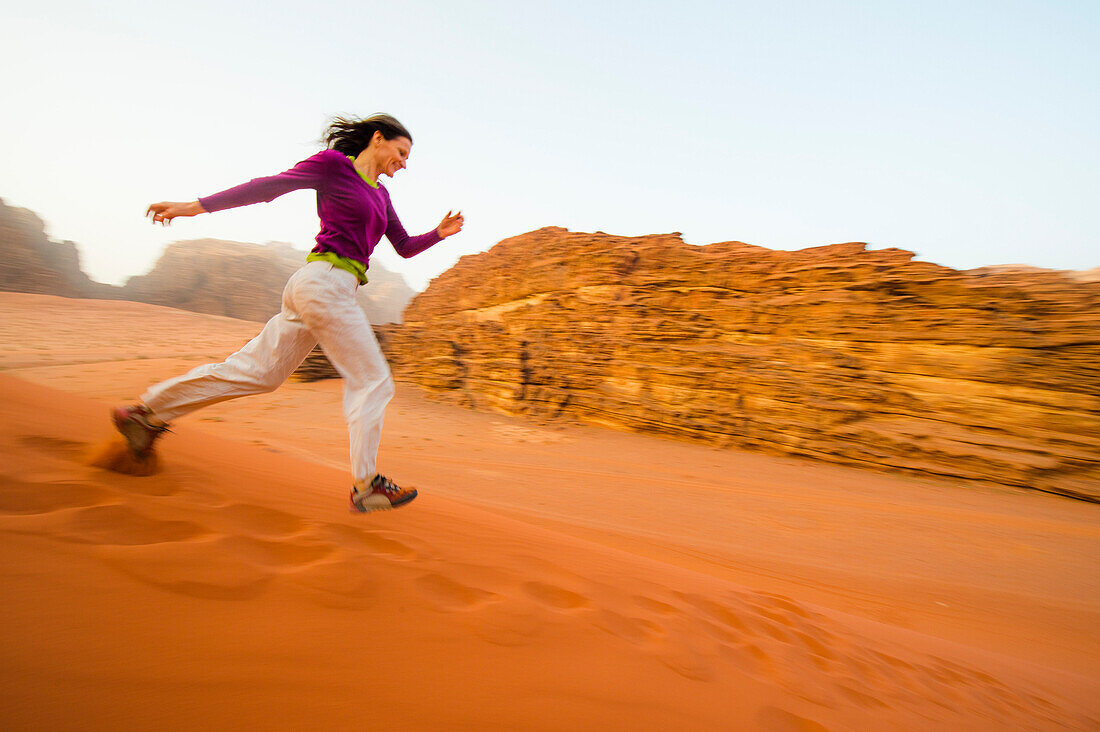 Frau läuft eine Sanddüne hinab, Wadi Rum, Jordanien, Naher Osten