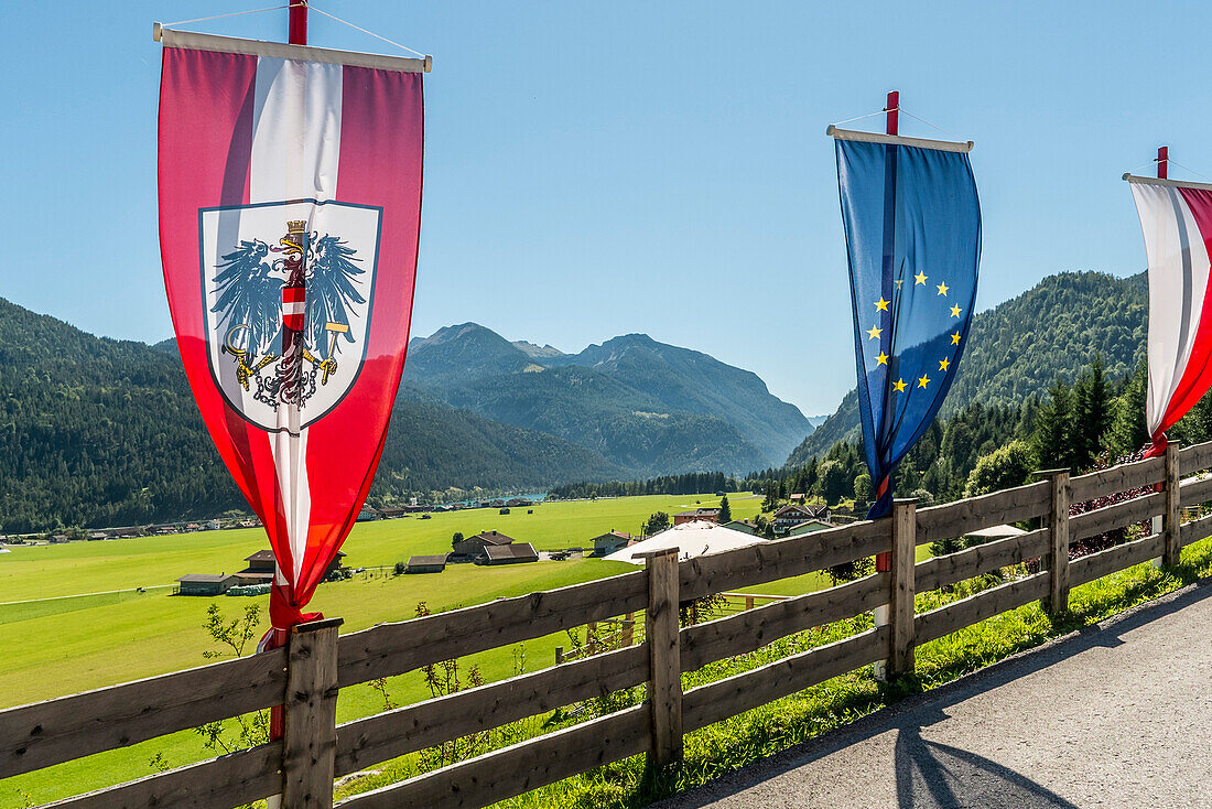 Flags at a fence, lake Achensee and Achenkirch in background, Tyrol, Austria
