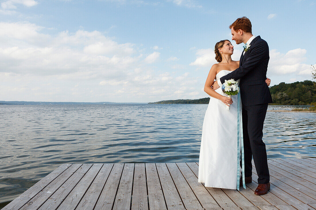 bridal couple is standing on jetty, Starnberger See, Bavaria, Germany