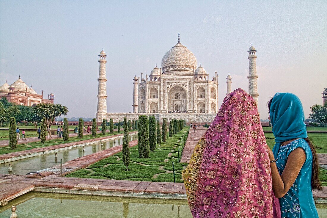 Hindu women with colorful veils in the quiet peaceful Taj Mahal one of the wonders of the world in Agra India