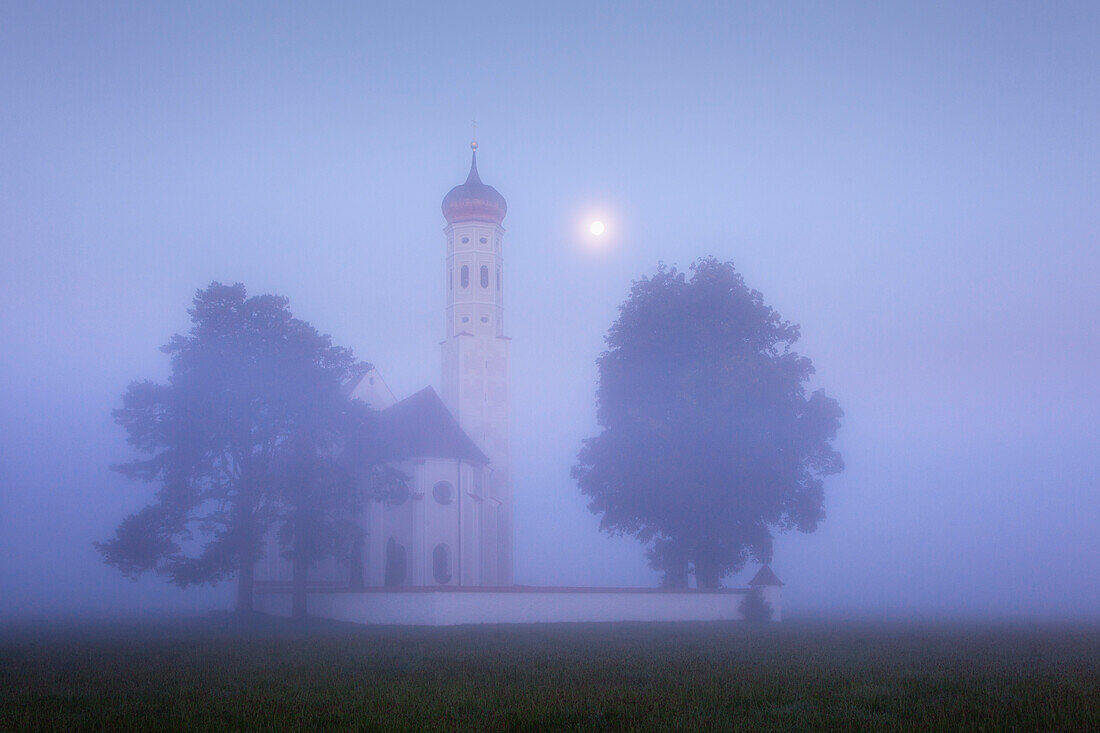 Wallfahrtskirche St. Coloman in Morgennebel und Mondlicht, bei Hohenschwangau, Füssen, Allgäu, Bayern, Deutschland