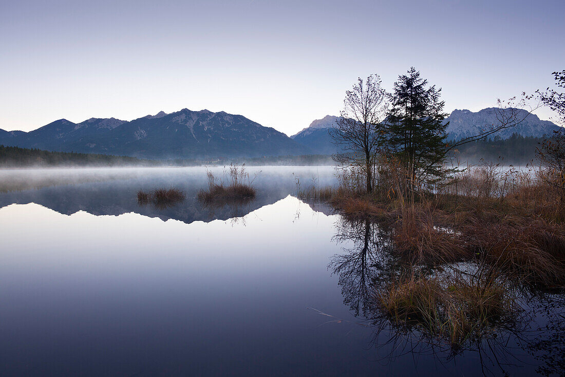 Morning mist, view over lake Barmsee to the Soiern mountains and Karwendel mountains, near Mittenwald, Bavaria, Germany