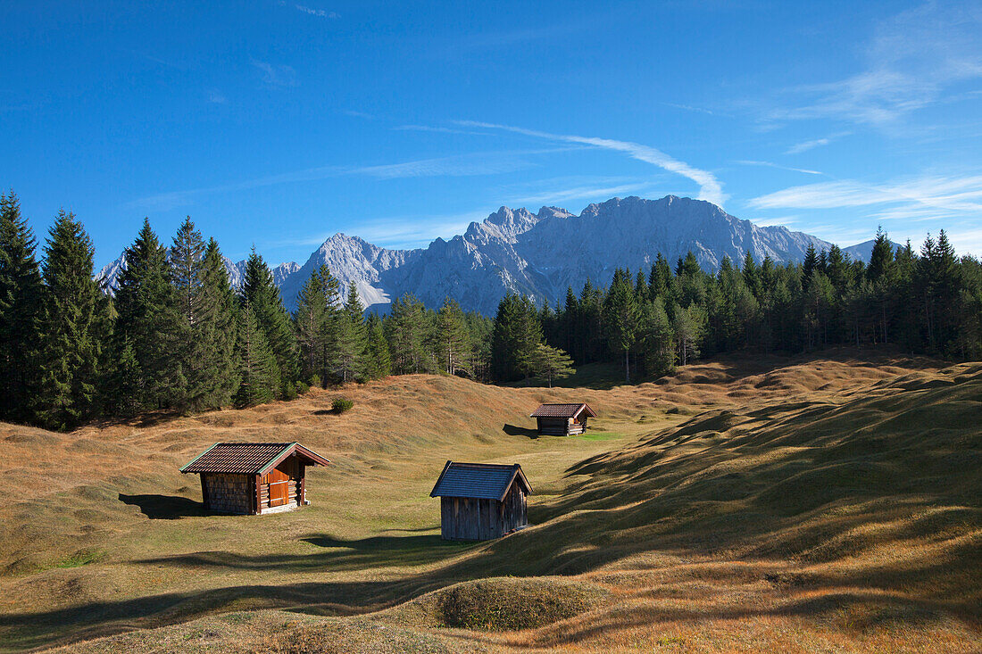 Mountain pasture with hay barns, view to the Karwendel mountains, near Mittenwald, Bavaria, Germany