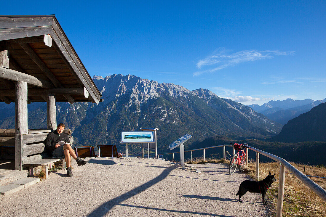 Wanderer bei der Rast an der Gipfelhütte auf dem Hohen Kranzberg, Blick zum Karwendelgebirge, bei Mittenwald, Bayern, Deutschland