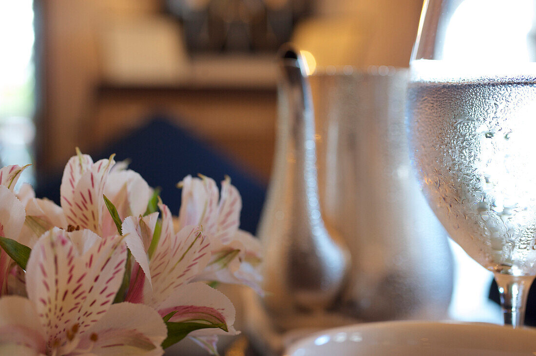 Condensation on a glas of water, teapot and flower blossoms, high tea at Luxury 5 Star Hotel Amangalle, Galle, Southwest Sri Lanka