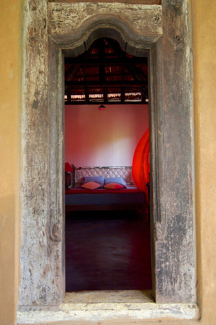 Blick durch Tür in einen rustikalen Raum des Eco Hotels The Samadhi Center in den Bergen bei Kandy, Sri Lanka