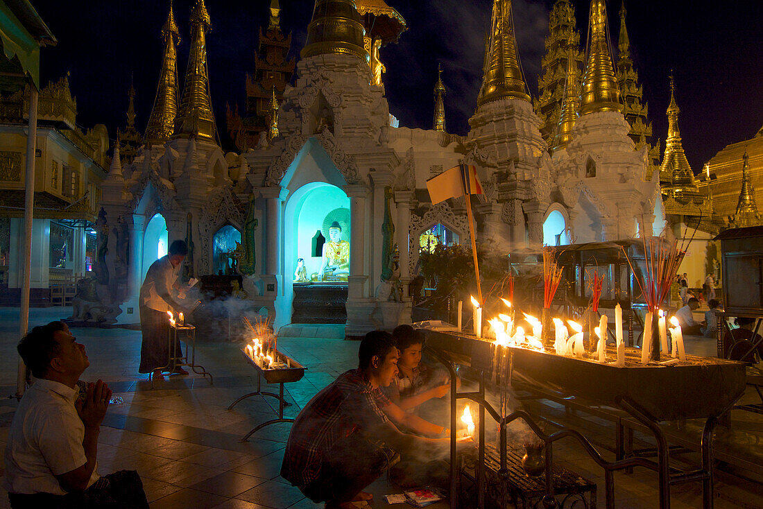 Burmese people lighting candles at the Shwedagon Paya, Yangon, Rangoon, Myanmar, Burma